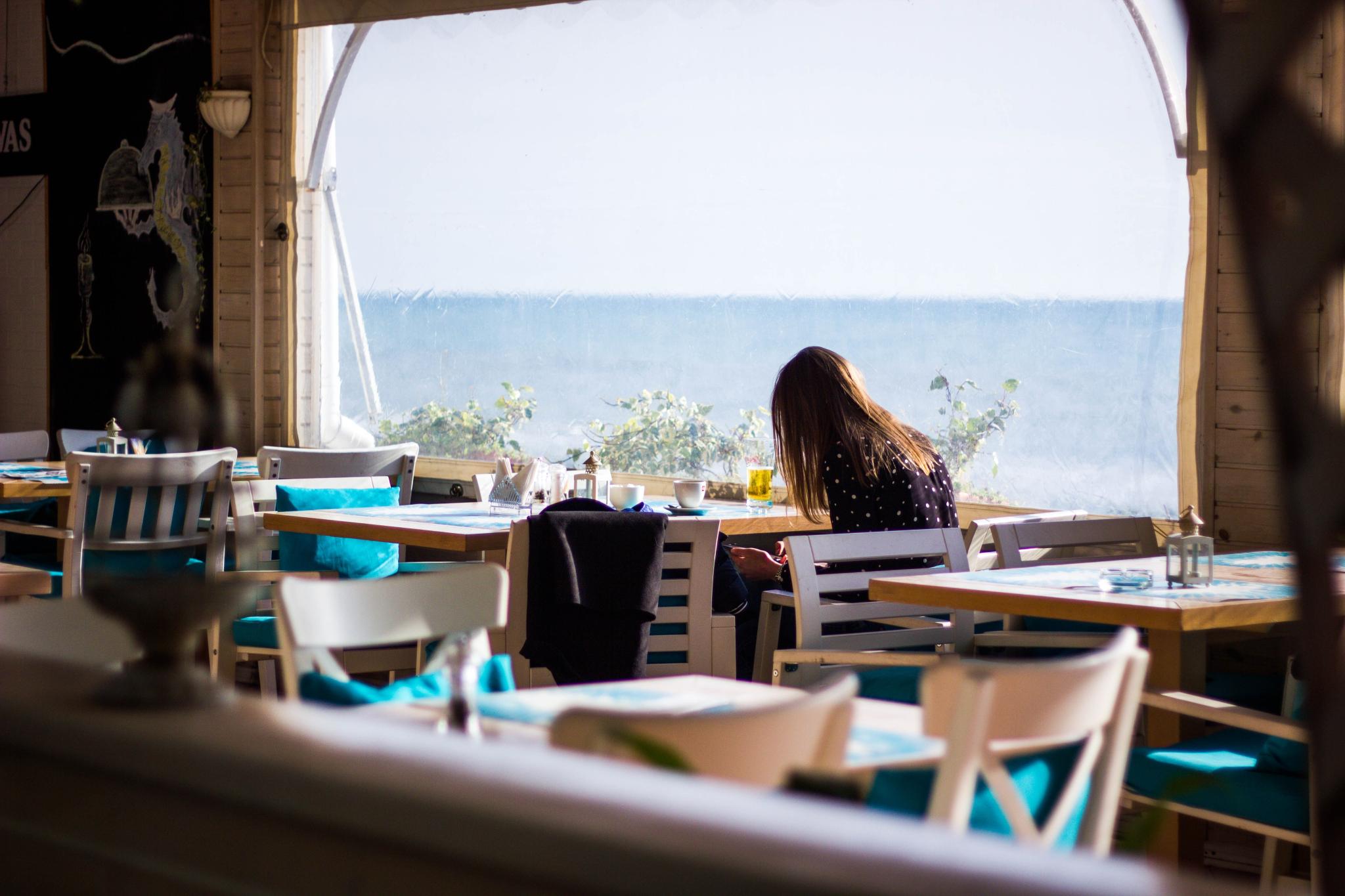 chica en un restaurante con vista al mar